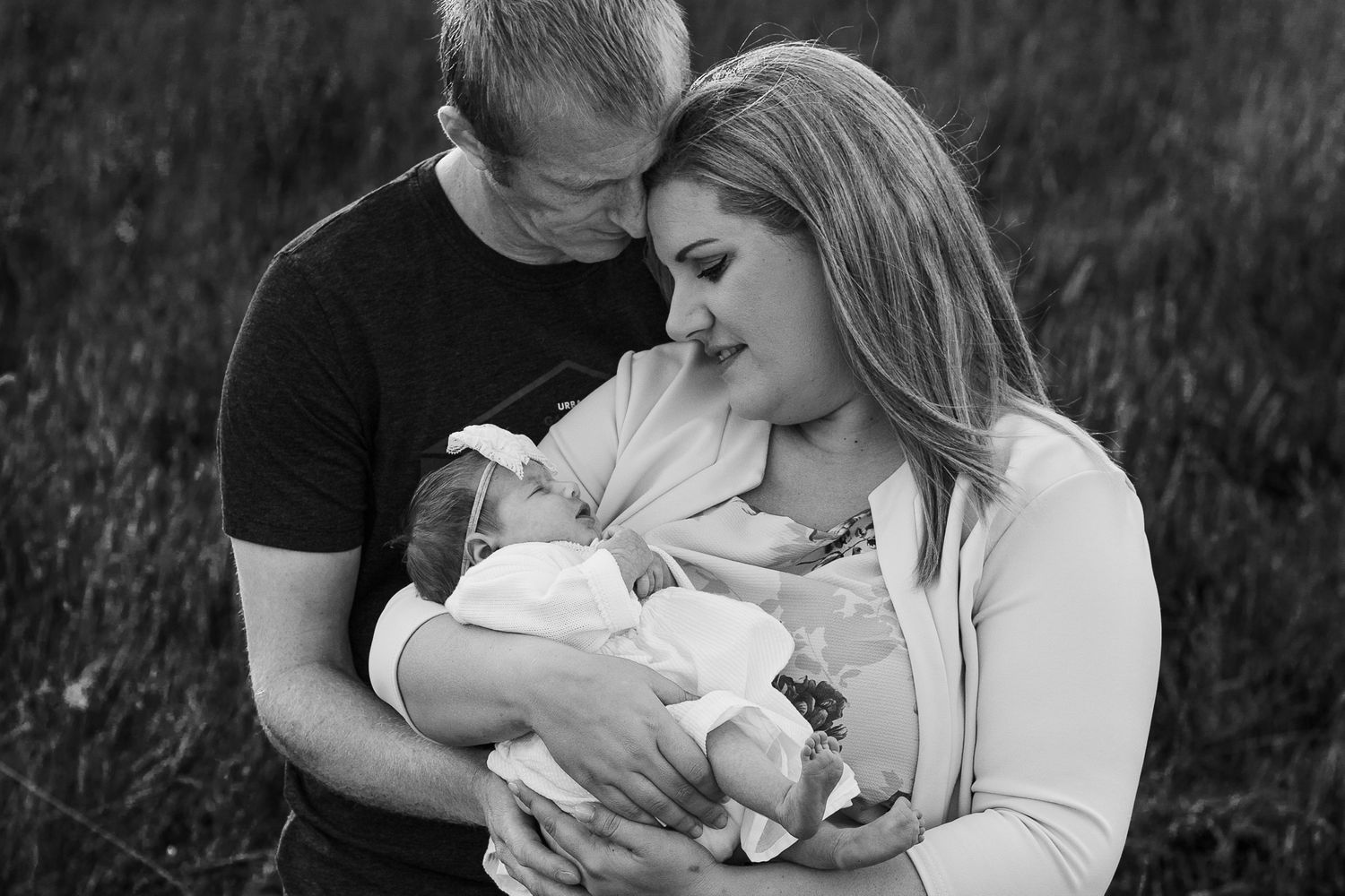 in a field in Havant new parents look lovingly on their newborn baby girl.