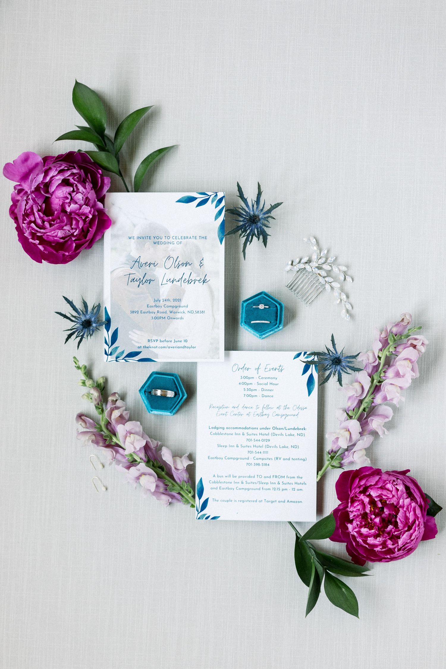 Bridal details flat lay of rings, jewelry, invitation suite, and florals