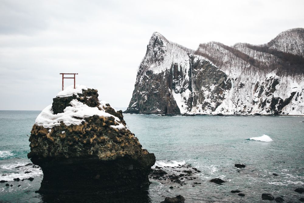 Torii gate on a sea stack in the sea of Japan, in Hokkaido winter