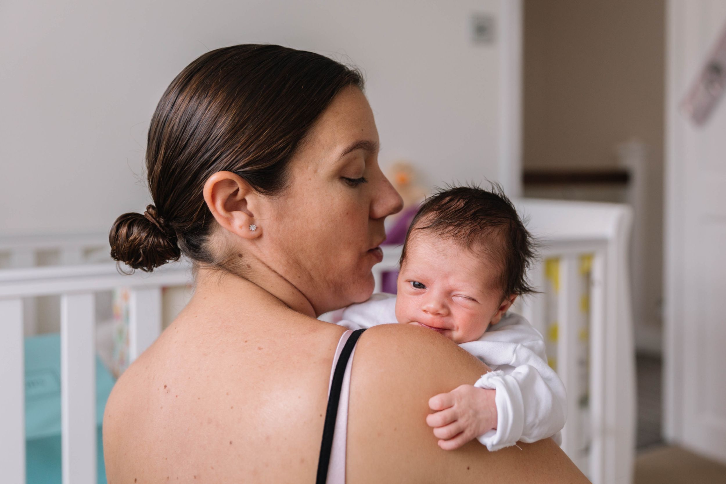 mum holding baby girl over shoulder