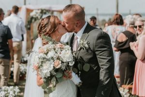 bride and groom kissing at the end of the alter