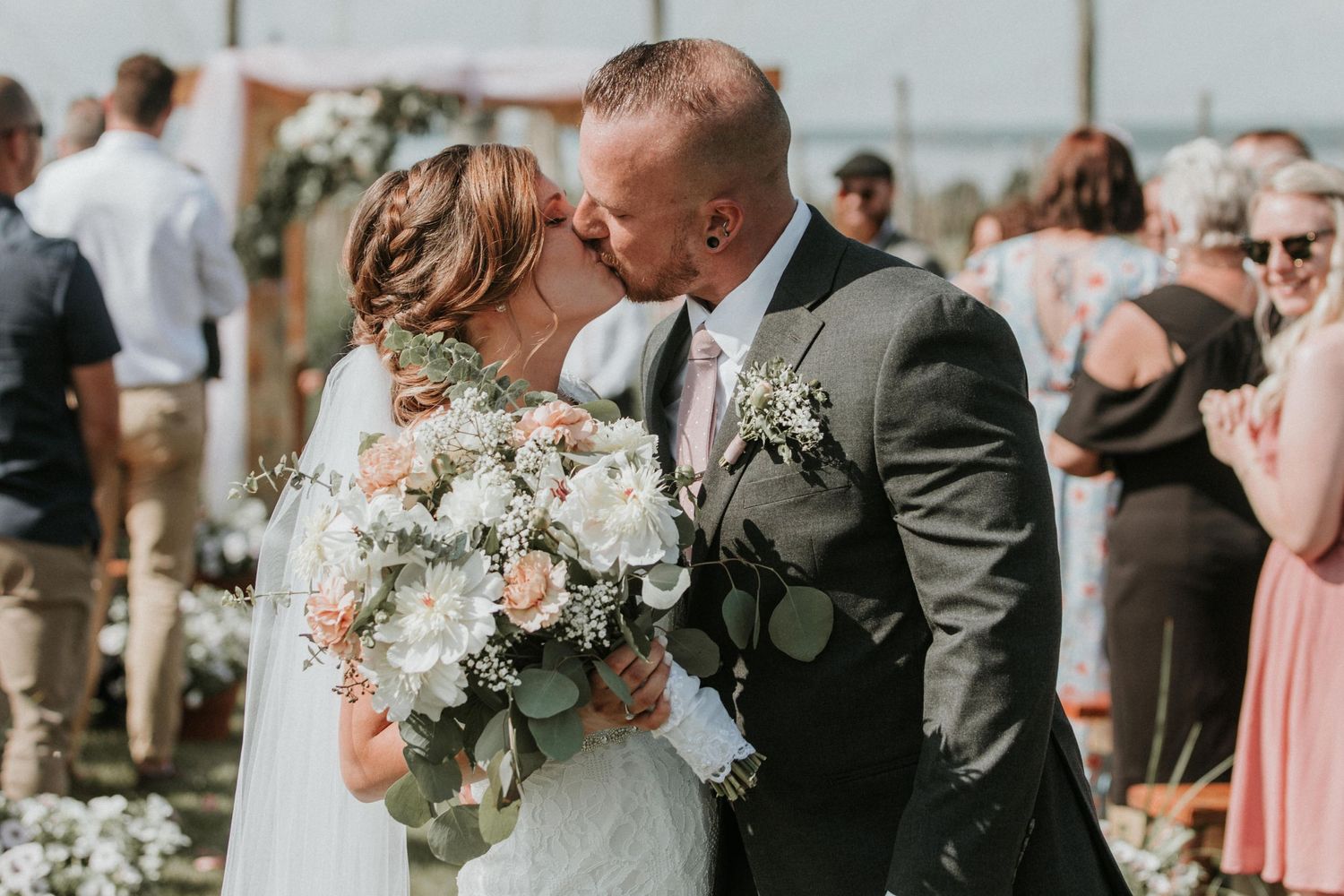 bride and groom kissing at the end of the alter