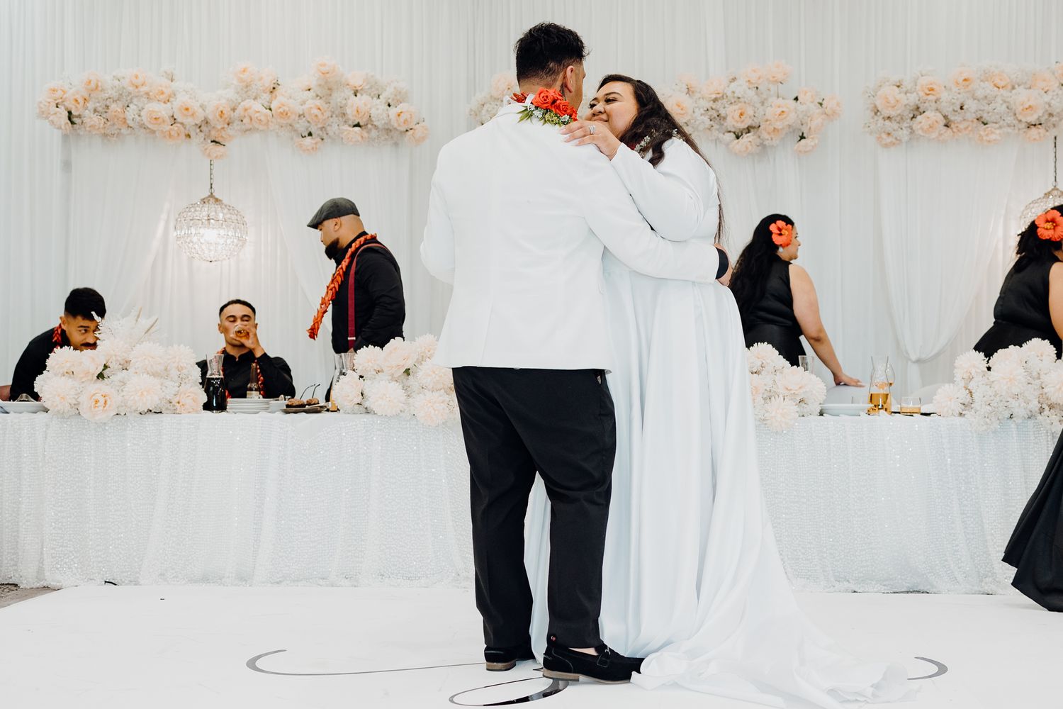 Couple shares first dance at elegant white-decorated wedding reception.