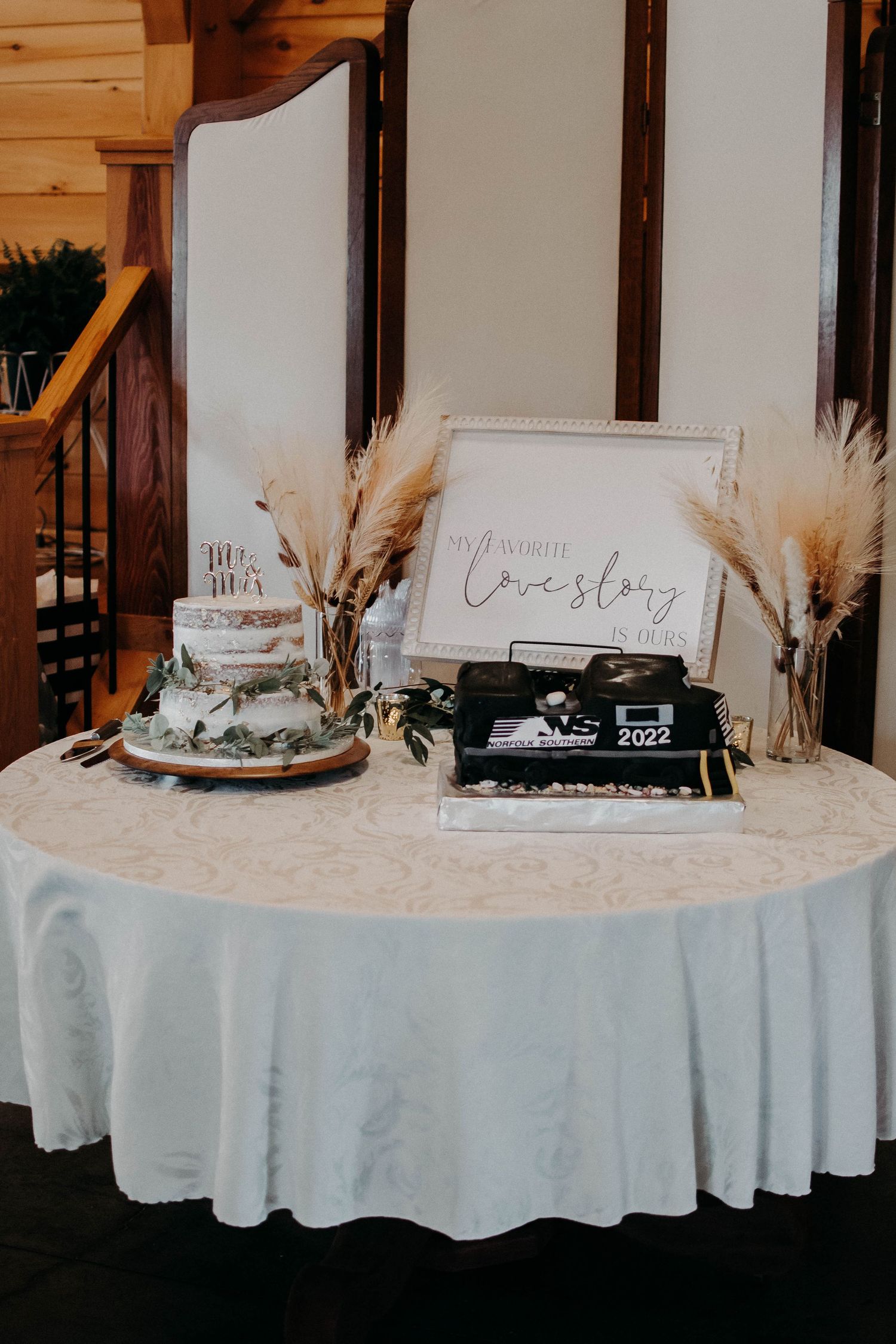 Vintage typewriter on wedding guest table with pampas grass and decorative signage.