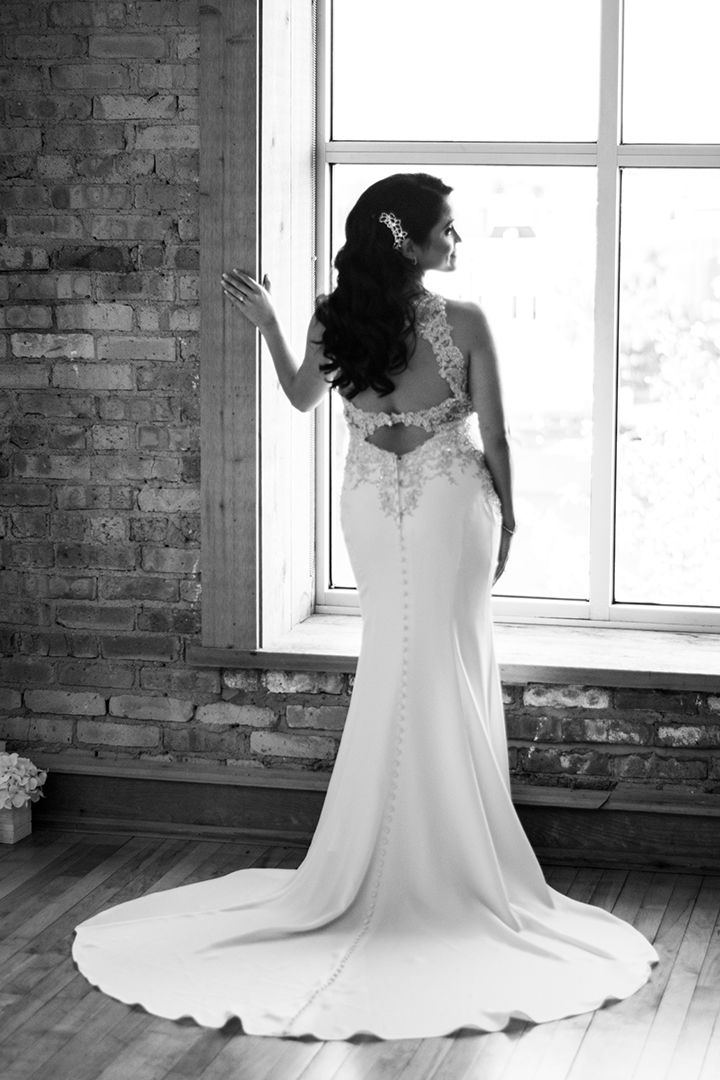 bride in black and white standing in window at Highland Loft bridal suite before wedding