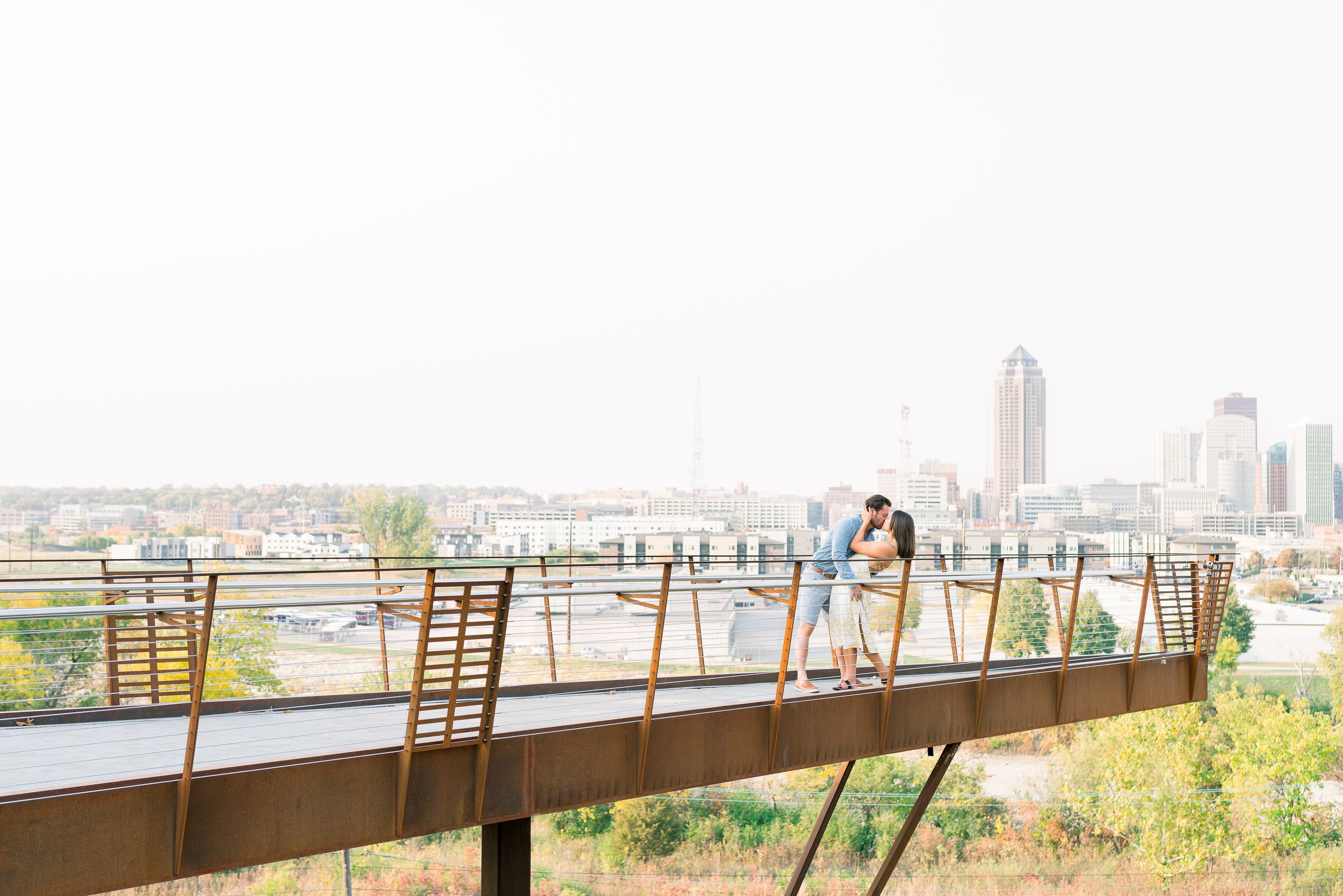 Des Moines Engagement photos with skyline of downtown Des Moines, Iowa with light and airy photographer Nicole Laing