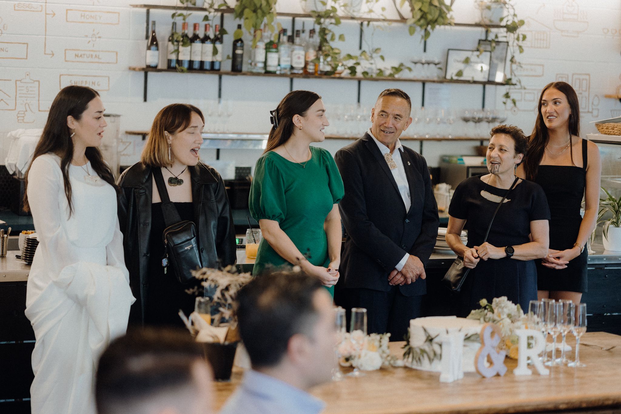 Wedding party gathering at modern cafe bar for casual celebration.
