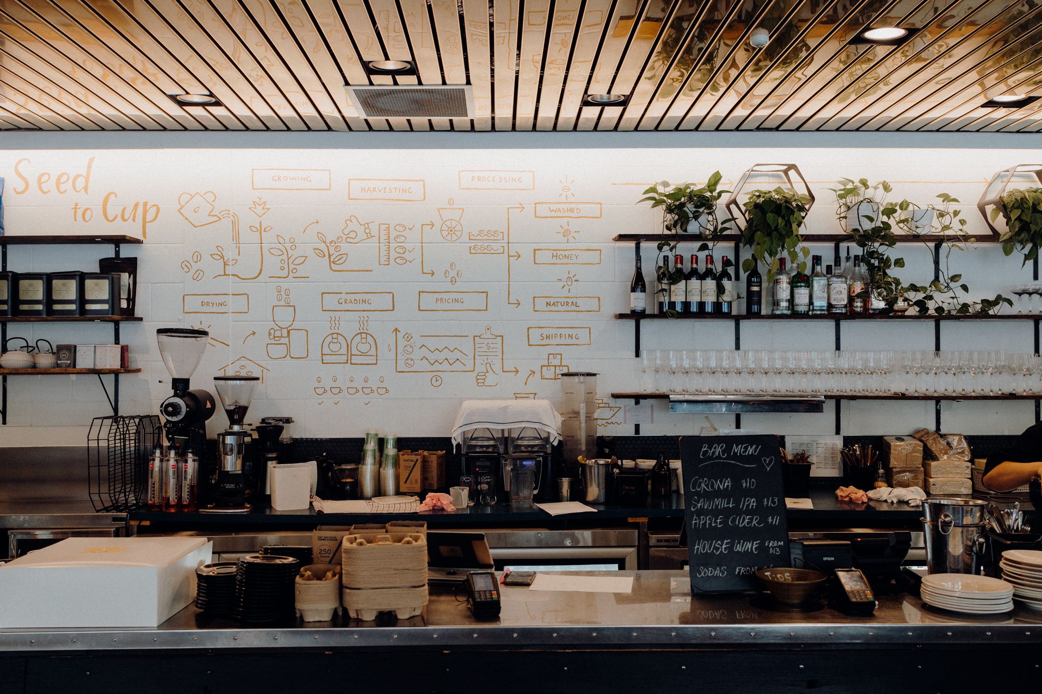 Modern coffee shop interior with white walls, wooden shelving, and minimalist decor.