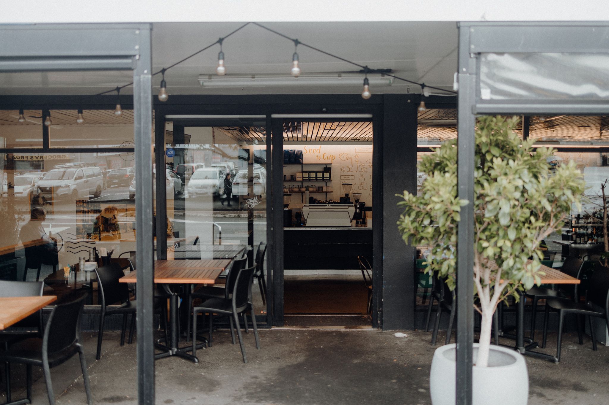 Contemporary cafe exterior with outdoor seating and modern black design elements.