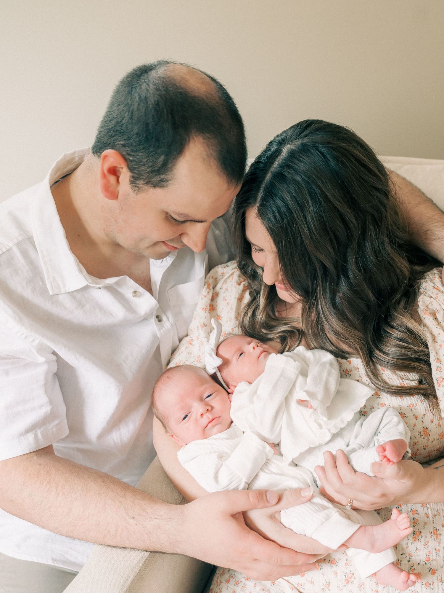A sweet family moment with newborn twins being cradled together.