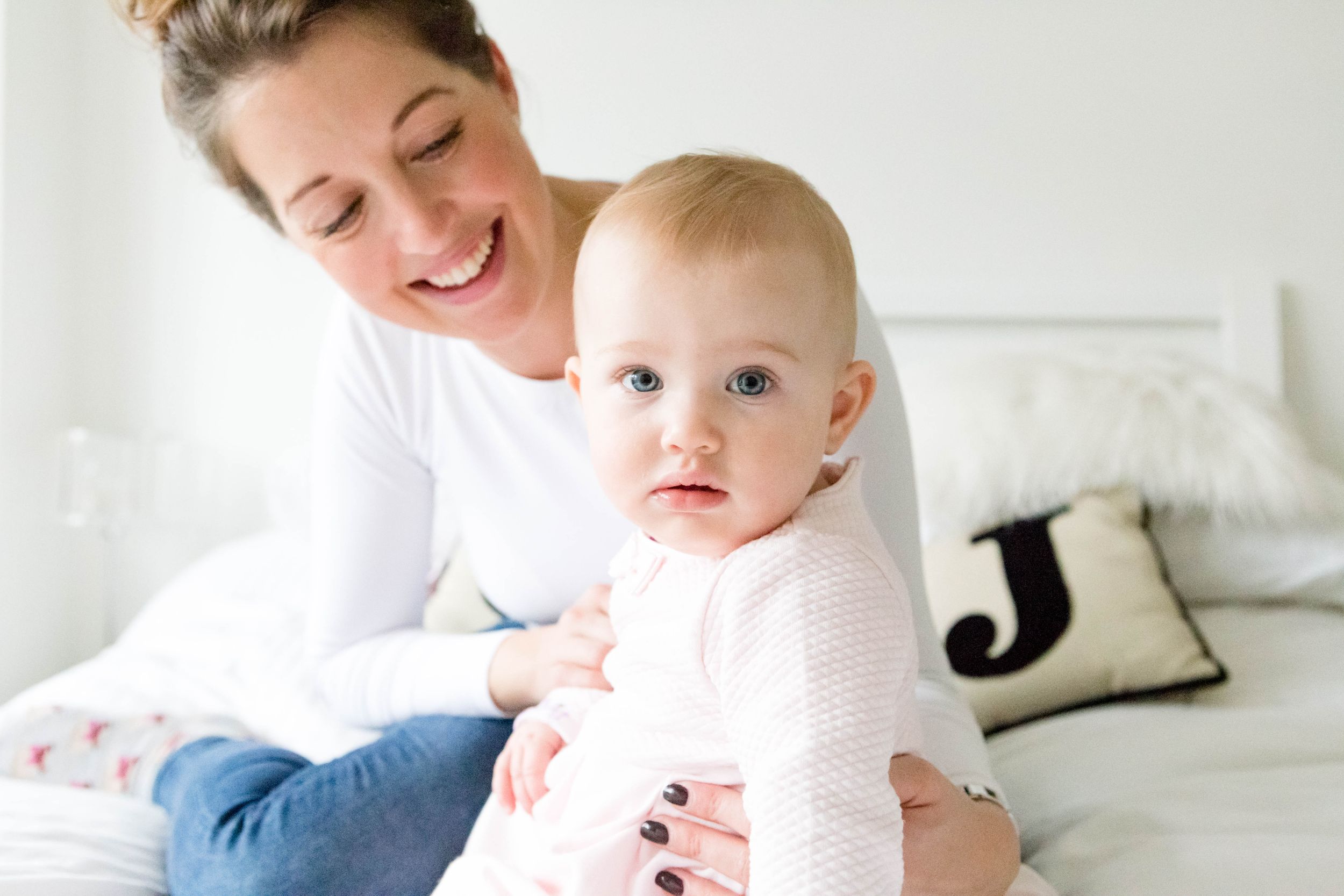 1 year old baby girl at home on bed with mum