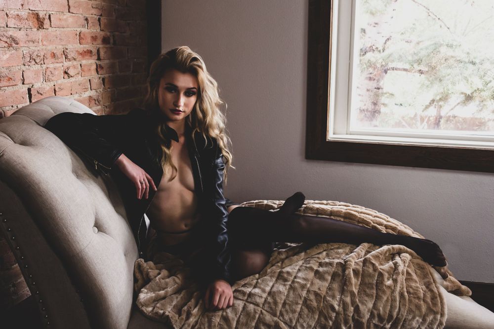 BEAUTIFUL WOMAN LOOKING SEDUCTIVE IN A LEATHER JACKET AND DEADLY BLONDE HAIR