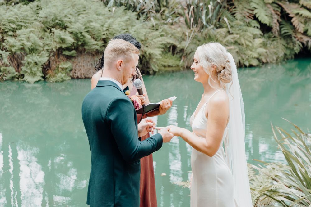 Intimate wedding ceremony moment as couple exchanges vows by turquoise waters.