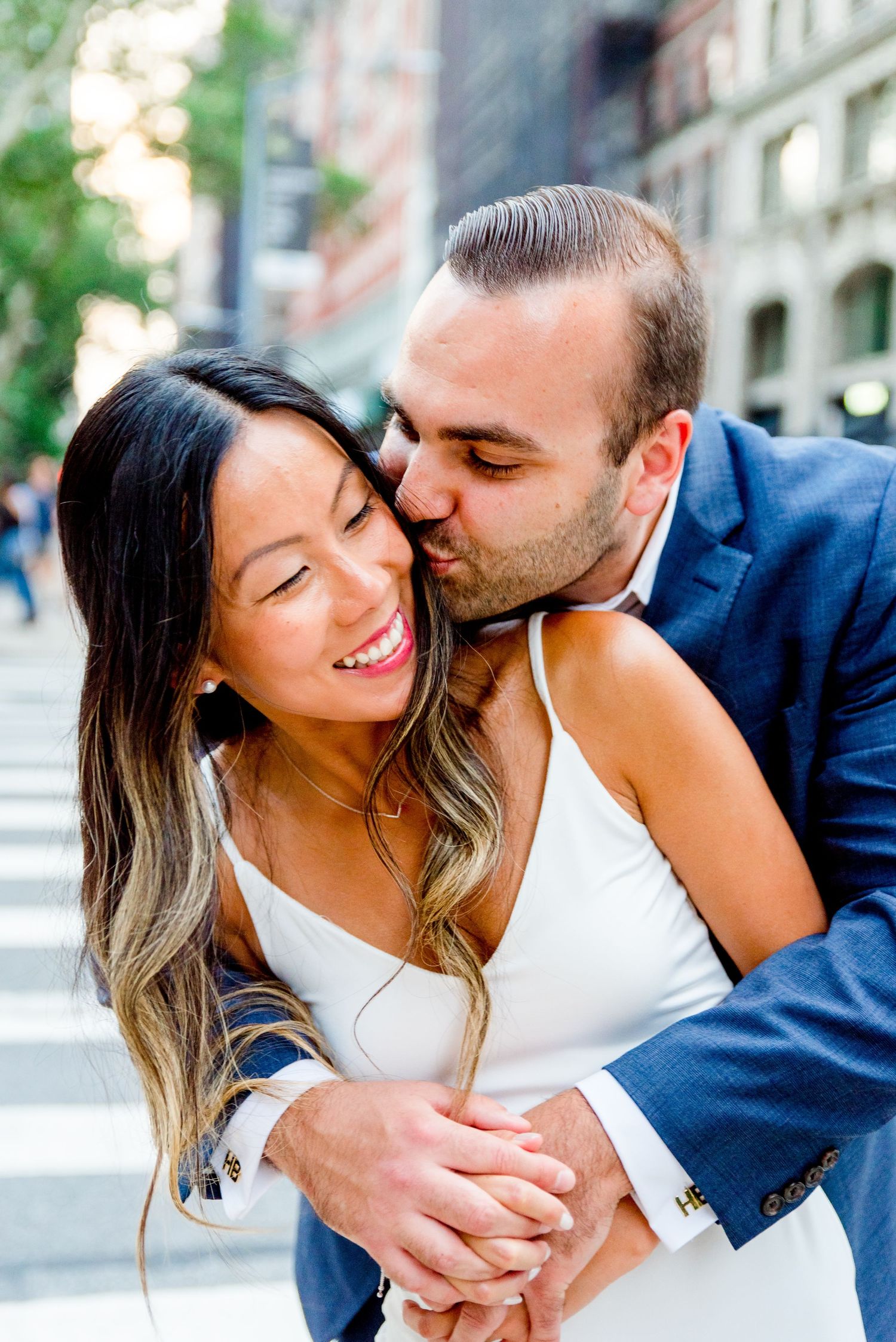 man kissing fiance on cheek in Flatiron District, NYC engagement photos