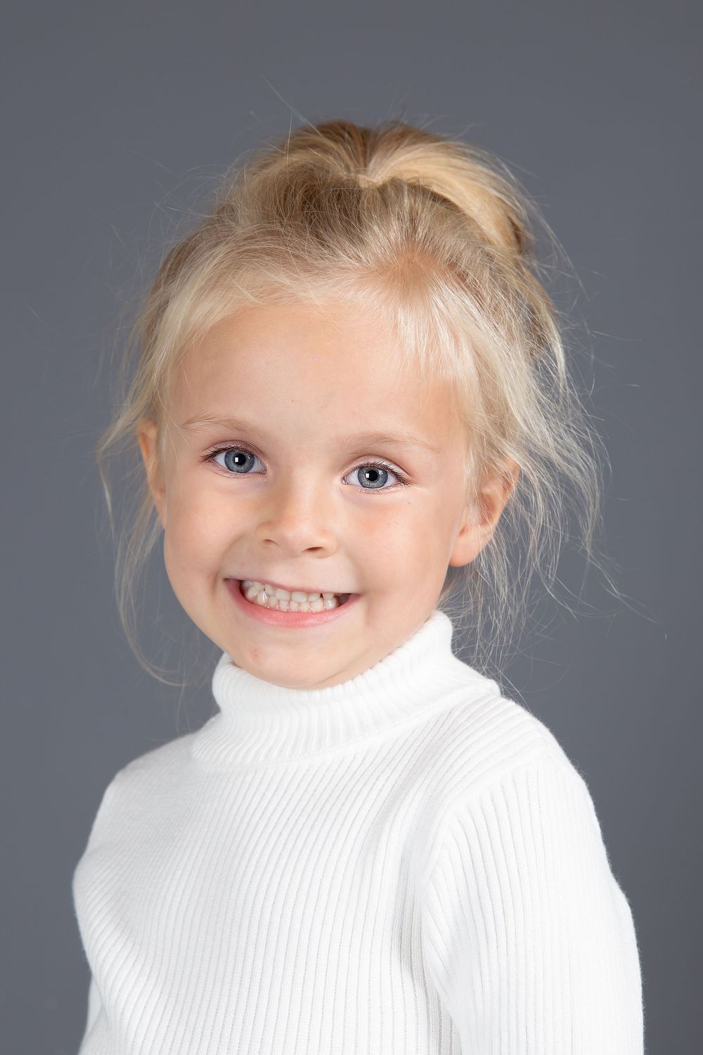 child model headshot on grey background with white top and hair up