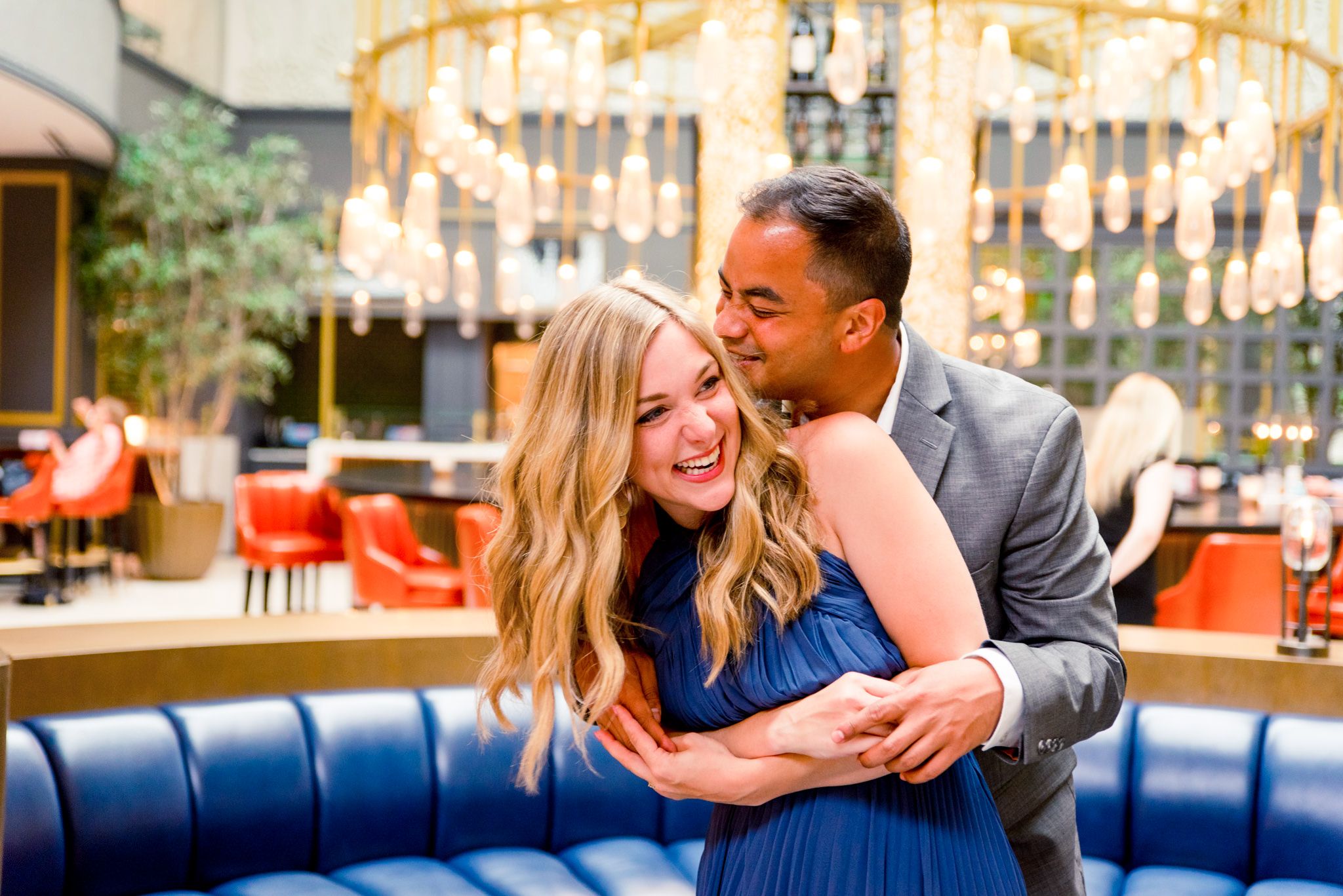 man kissing woman and she laughs in the lobby of the Lytle Park Hotel in Cincinnati