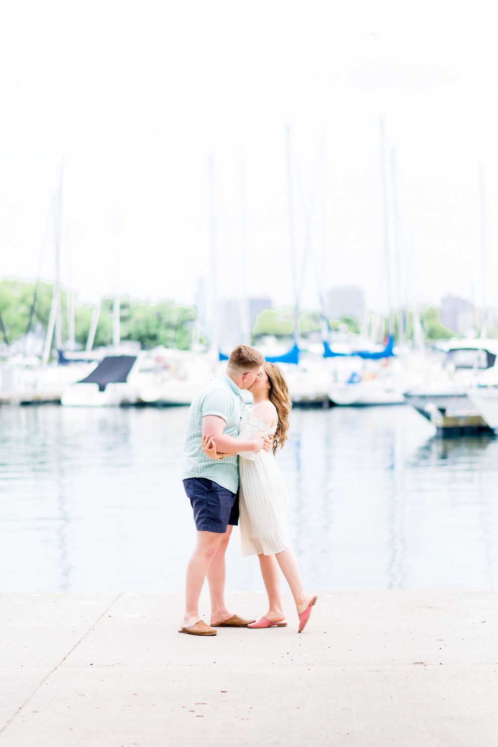 engaged couple hugging and kissing at Montrose Harbor in Chicago for sunrise engagement pictures