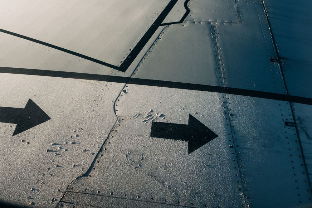 Black directional arrows painted on gray industrial surface show navigation guidance.