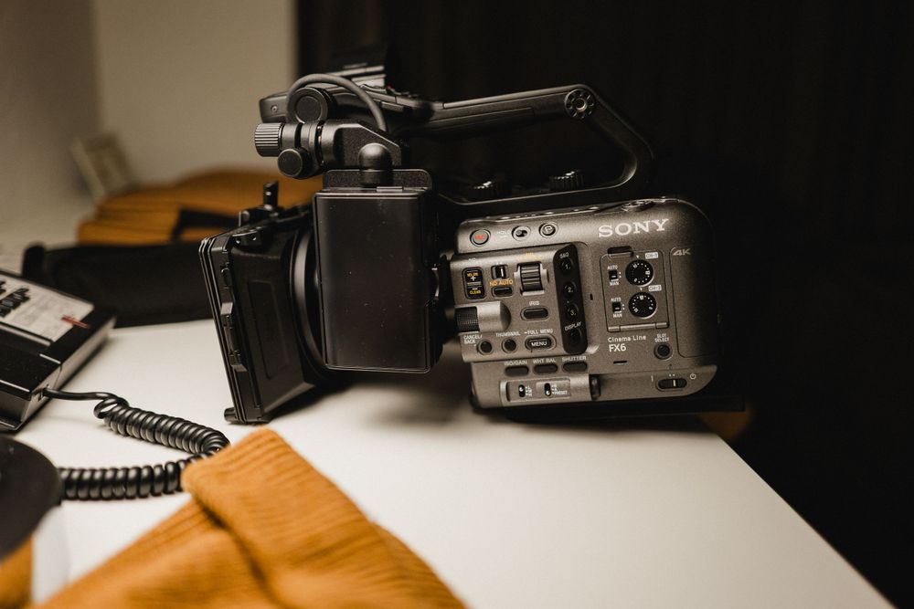 Professional video camera with controls and ports displayed on white surface.