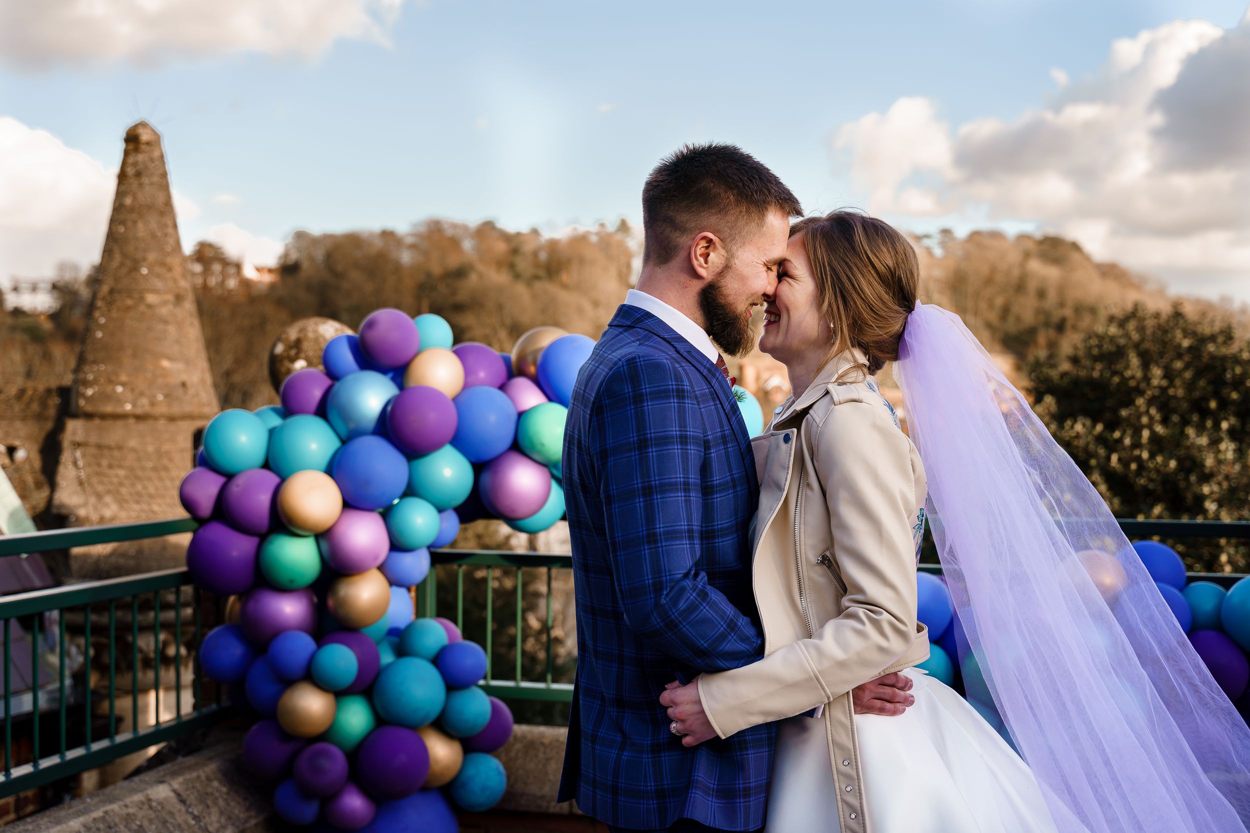 Colourful peacock wedding theme photography with balloons and a purple veil at Winchester Guildhall.