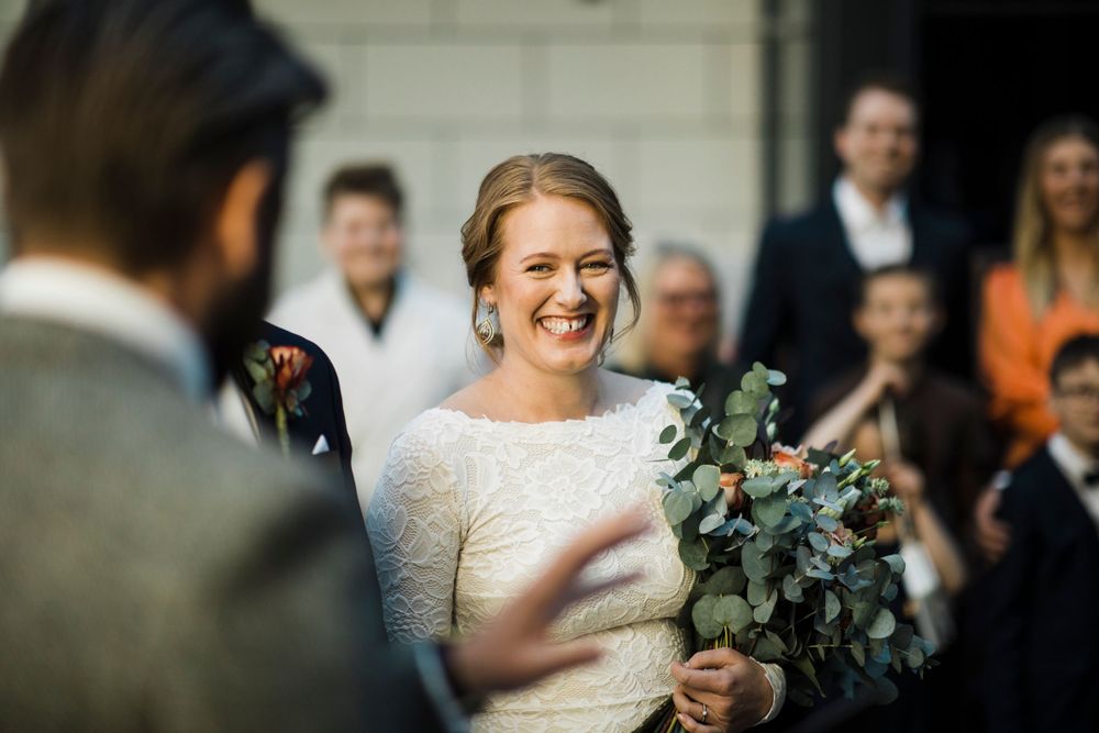 A joyful moment captured during a wedding celebration with greenery bouquet details.