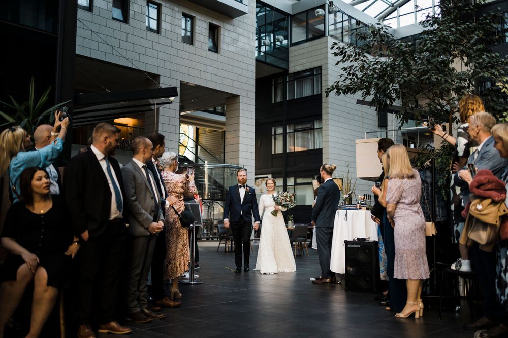 Wedding guests line up outdoors at an urban venue during an evening celebration.