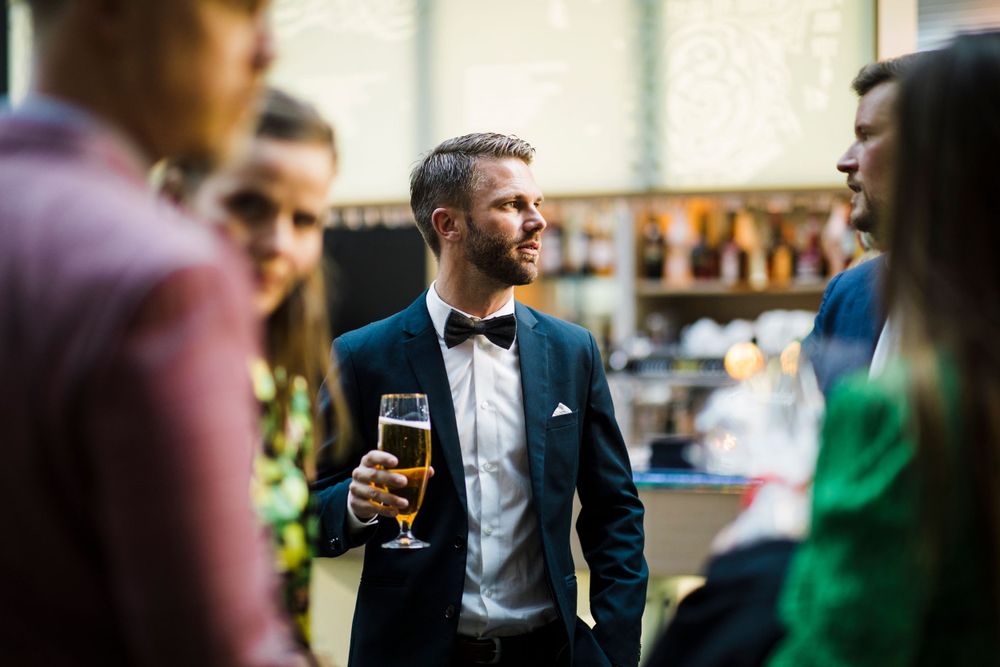 A social gathering with guests in formal attire enjoying drinks and conversation.