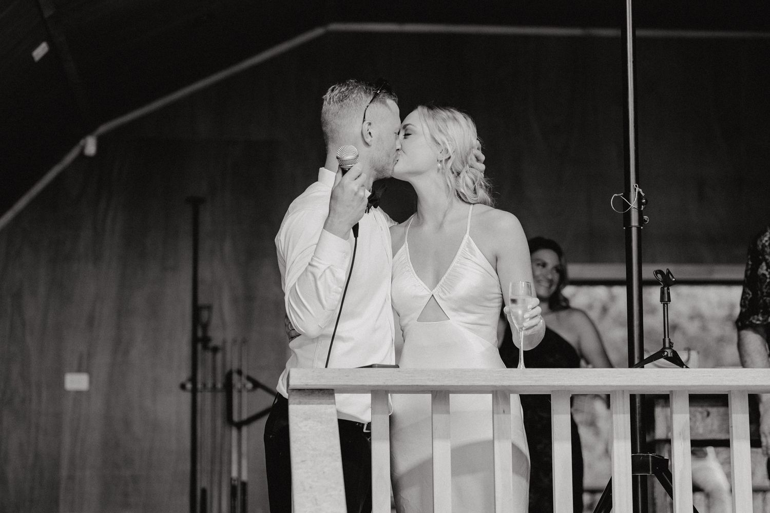 Black and white photo of performers singing on stage at an event.