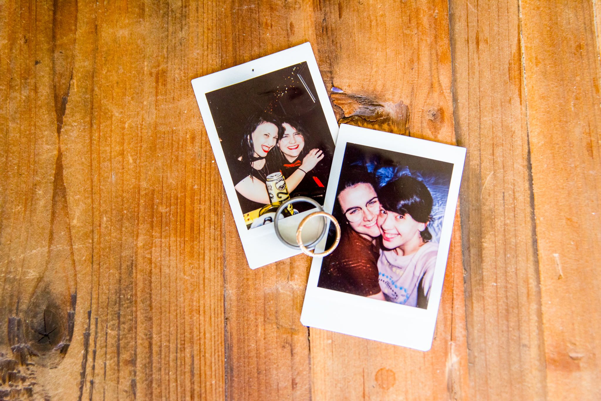 two polaroid photos of lesbian couple with their wedding rings on top