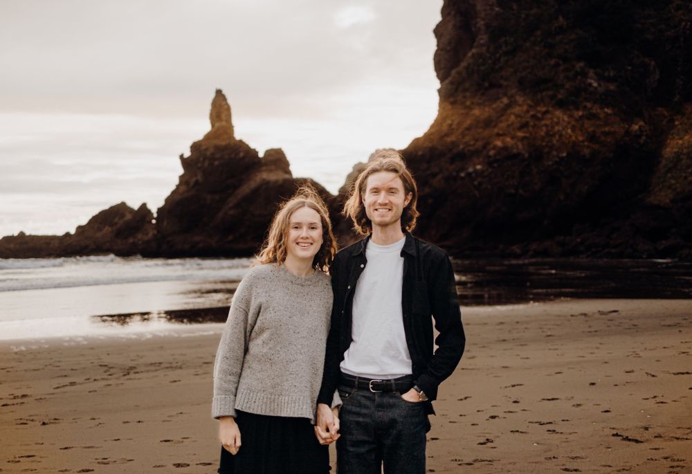 Lovers smiling in Piha for their engagement shoot with Apertured Media-Auckland Wedding and Engagement Photographer