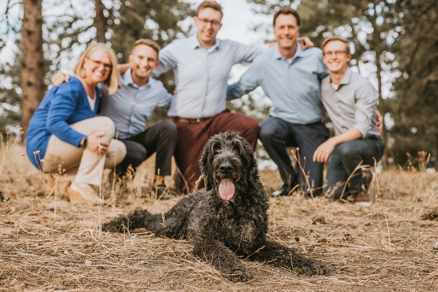 Family poses behind their dog during their Family Photography Session at Mount Falcon Trailhead in Morrison, Colorado.