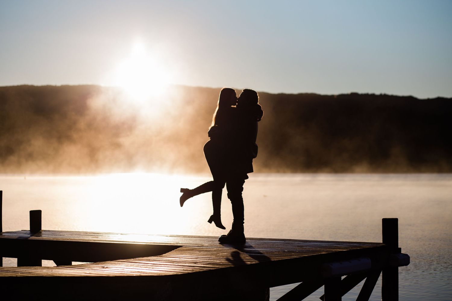 Newly engaged couple kissing with Taraera sunrise backdrop