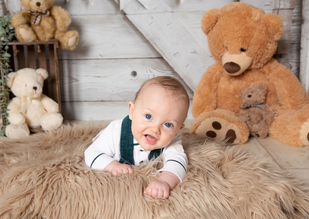 baby on tummy fur rug with teddies in background