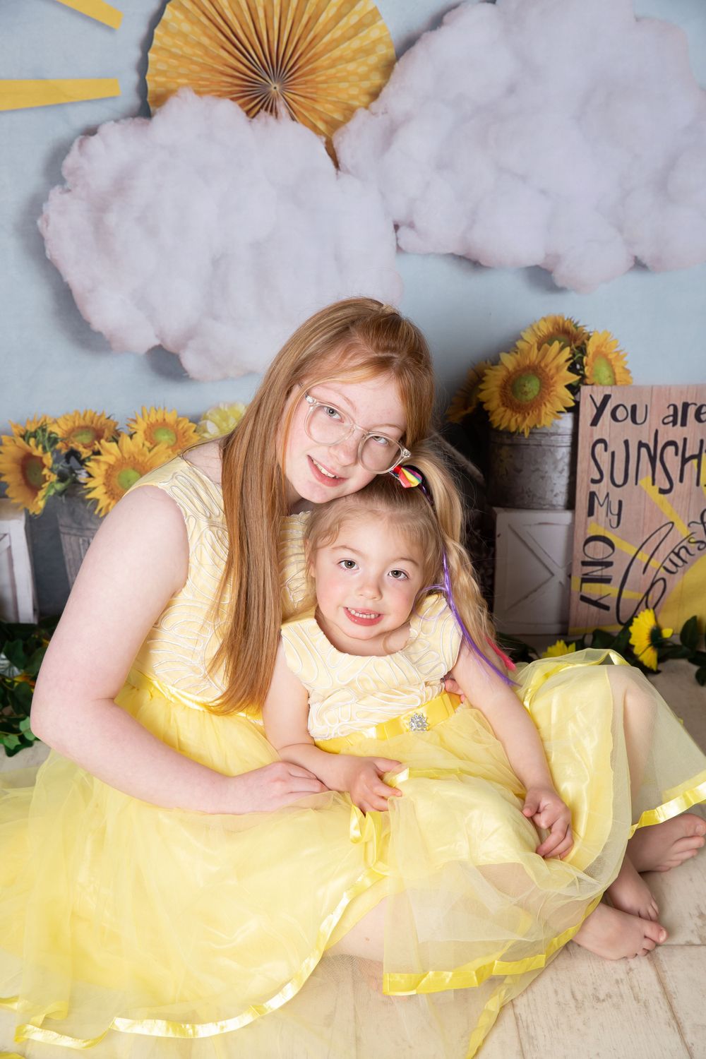 2 girls cuddling in yellow dresses