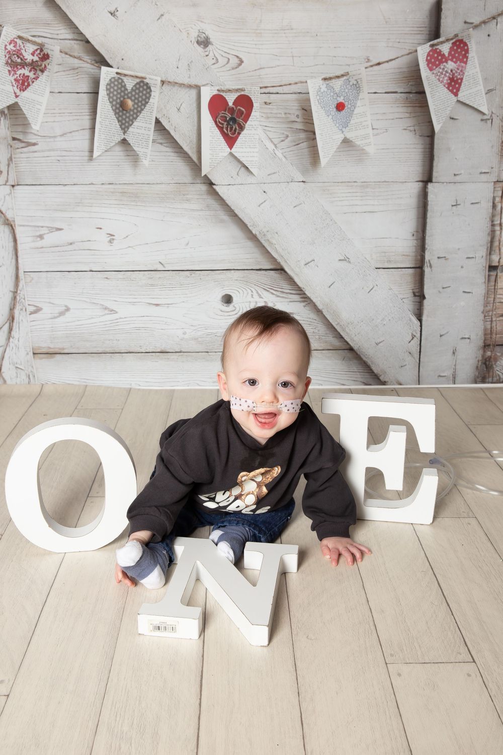 little boy holding one letters smiling at camera