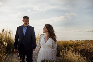Bride and groom walk down the beach holding hands during wedding day with wedding photographers near Hartford ct