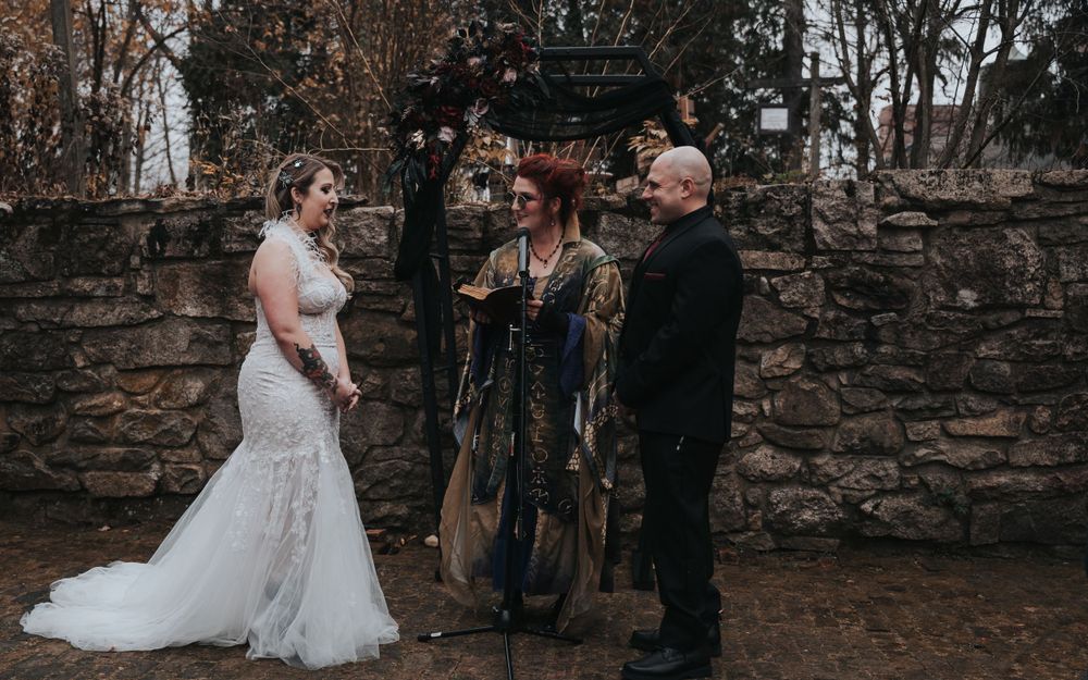 Bride, officiant, groom under a coffin alter