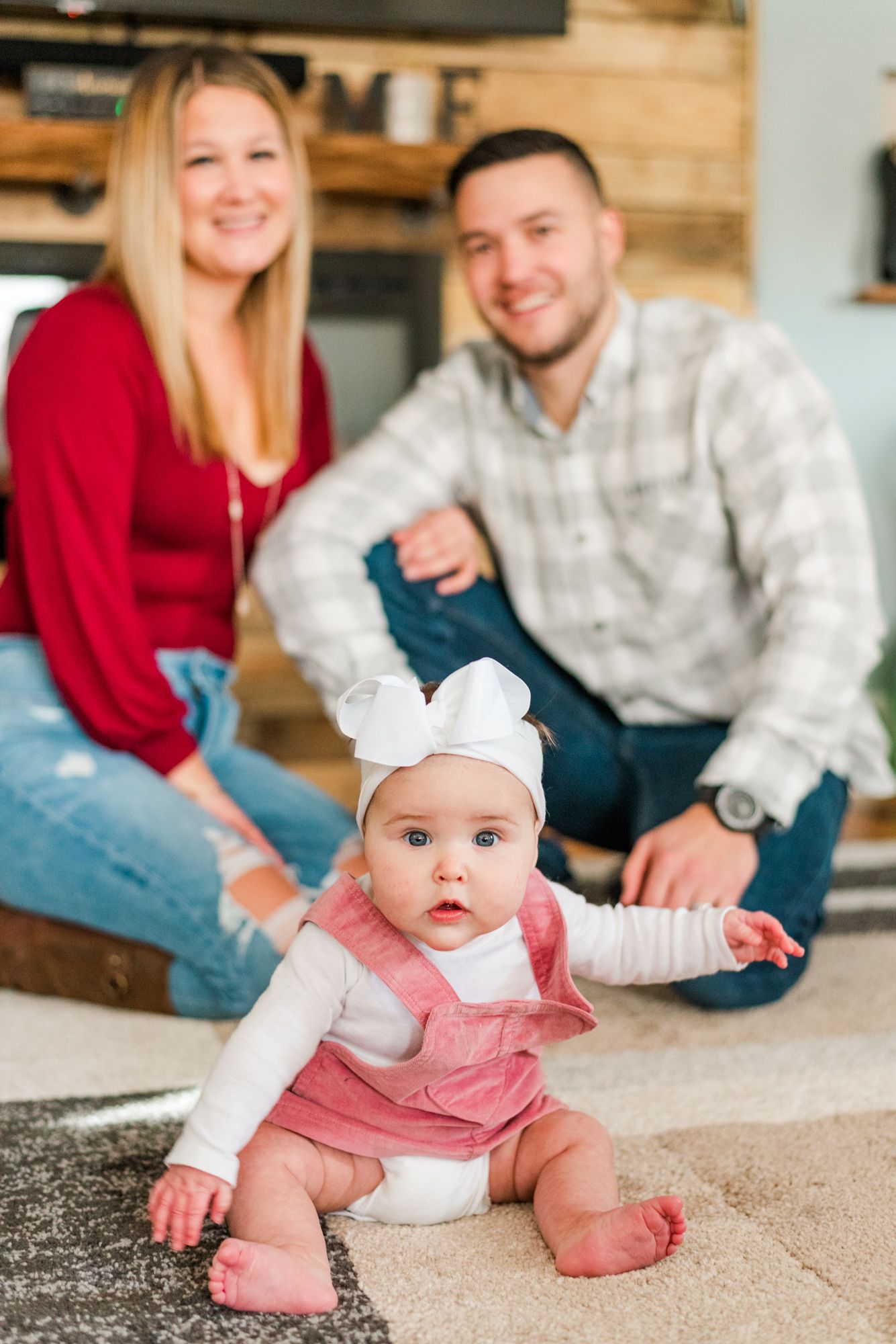 Lifestyle family photoshoot in the home with mom and dad and 6 month old baby wearing bow in Gibsonia, Pennsylvania