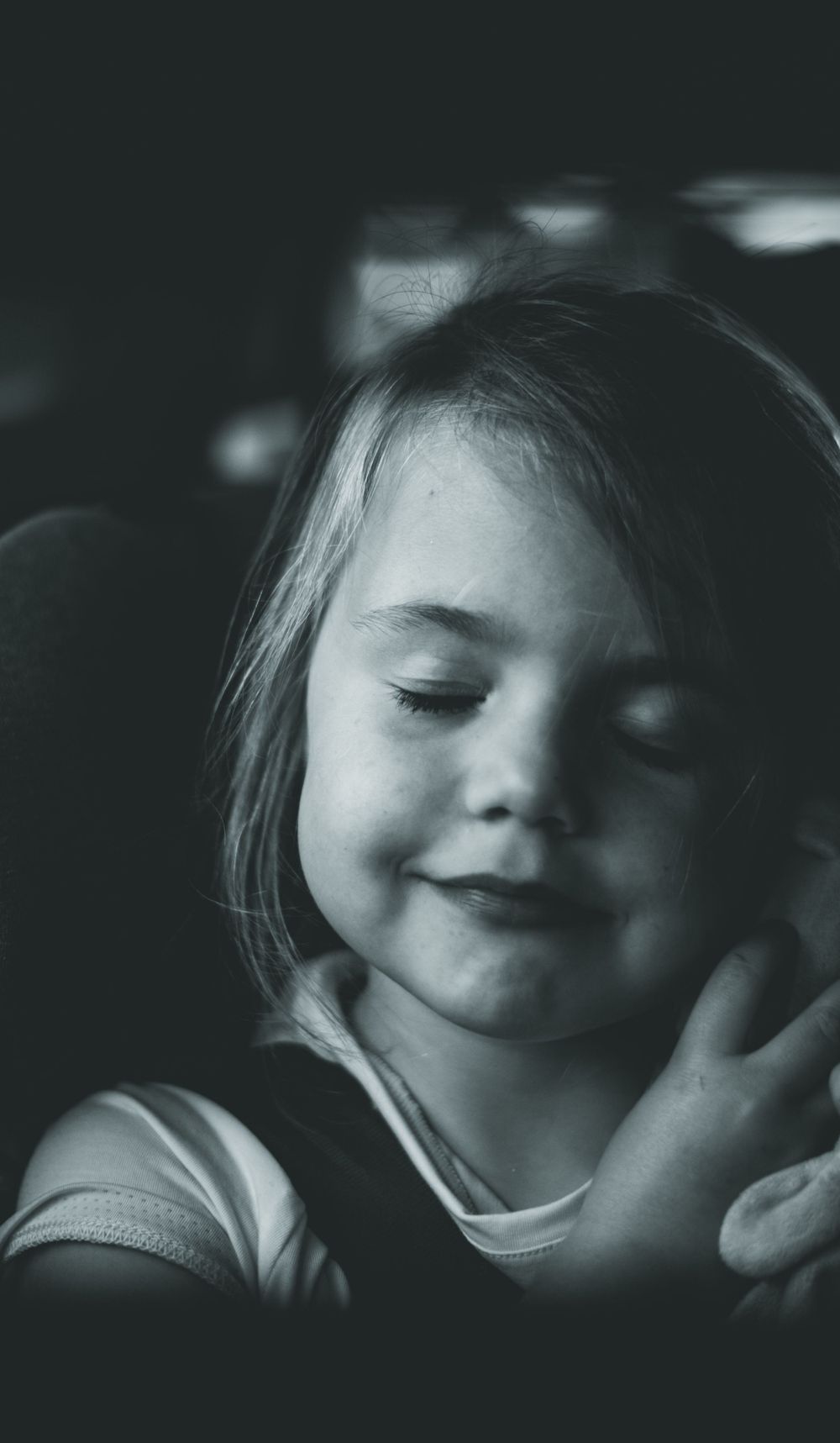zwart wit foto van slapend meisje in de auto