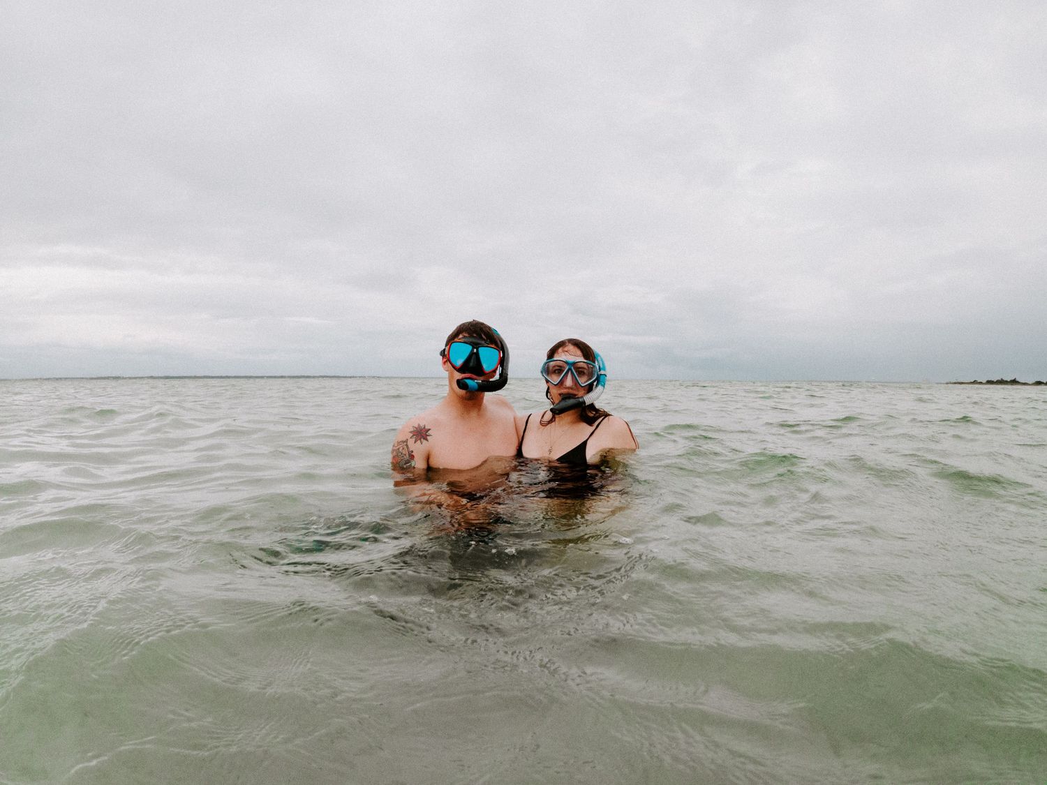 couple looking at the camera with their snorkeling gear on
