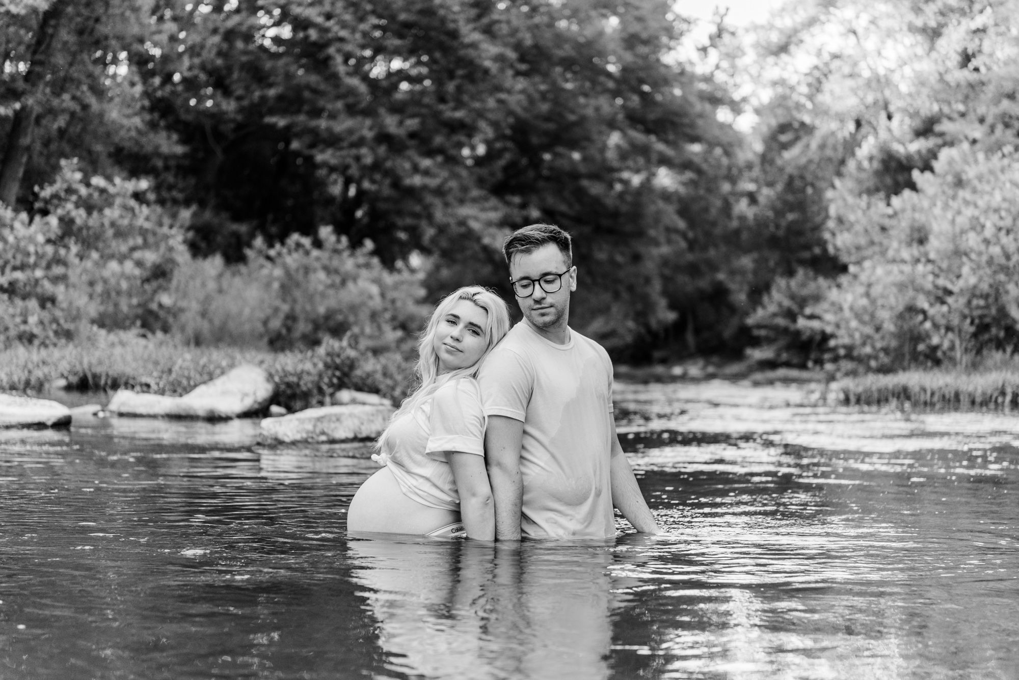 Intimate maternity photos in jeans and white shirt in stream in Zelienople, Pennsylvania