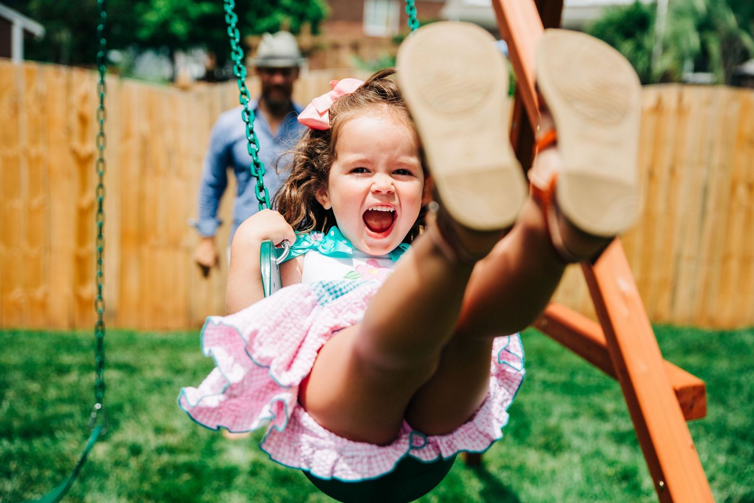Young girl swinging on swing during her fun family photos