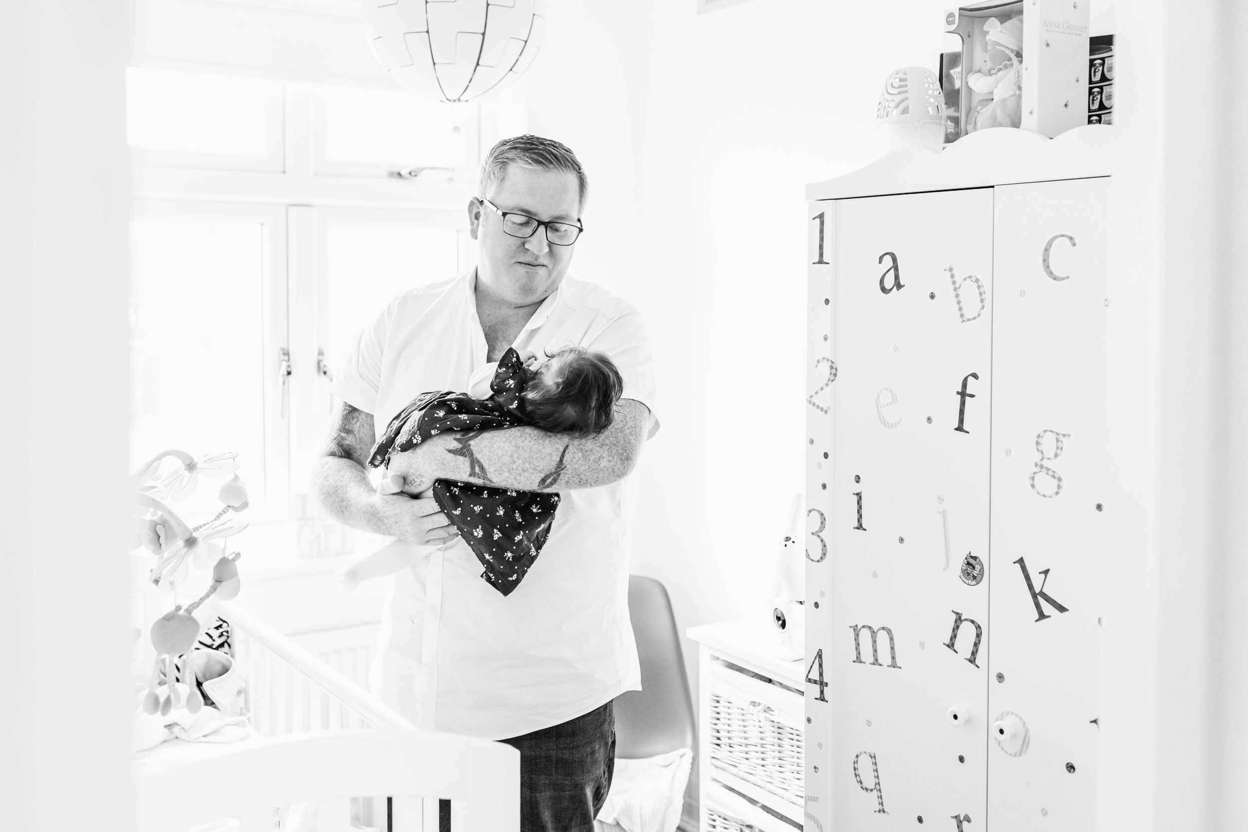 dad holding baby girl in his arms black and white