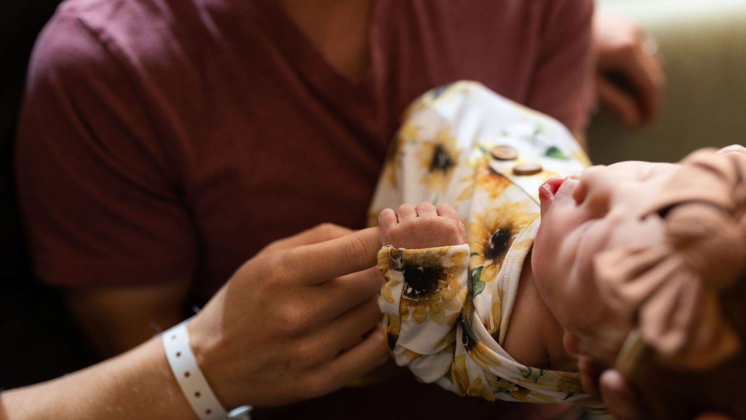 Newborn baby in dad's arms shortly after birth