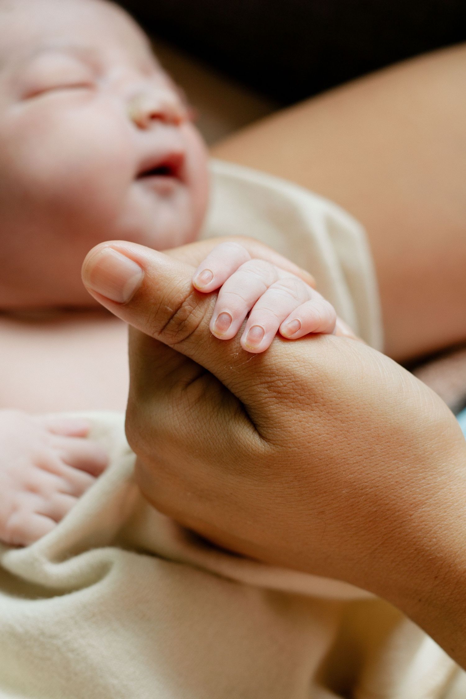 A photograph of a Newborn Baby born in Zanesville Ohio holding her mother's hand right after her birth