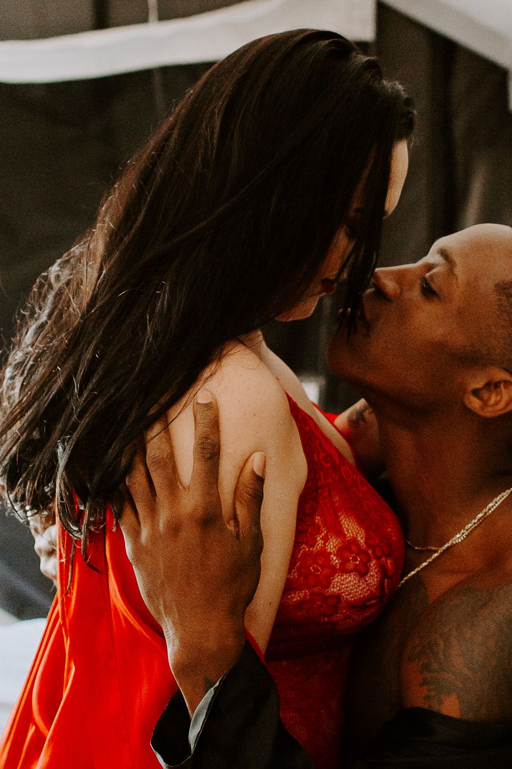man trailing his hands down a woman's back during their couples boudoir sessino