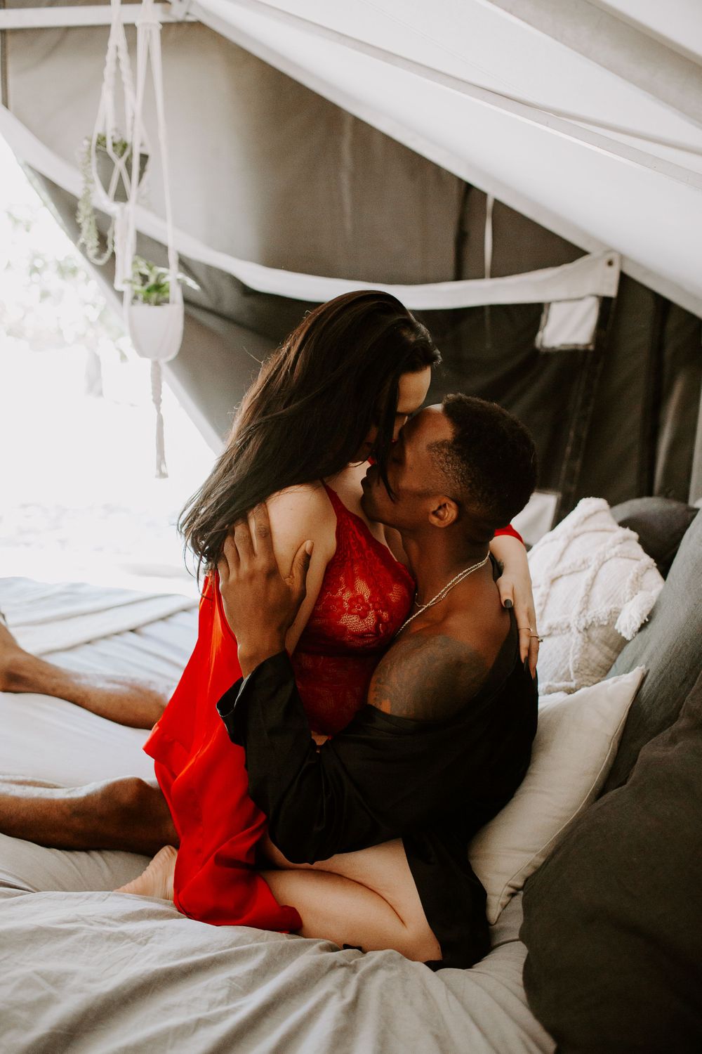 couple kissing on a bed during their couples session