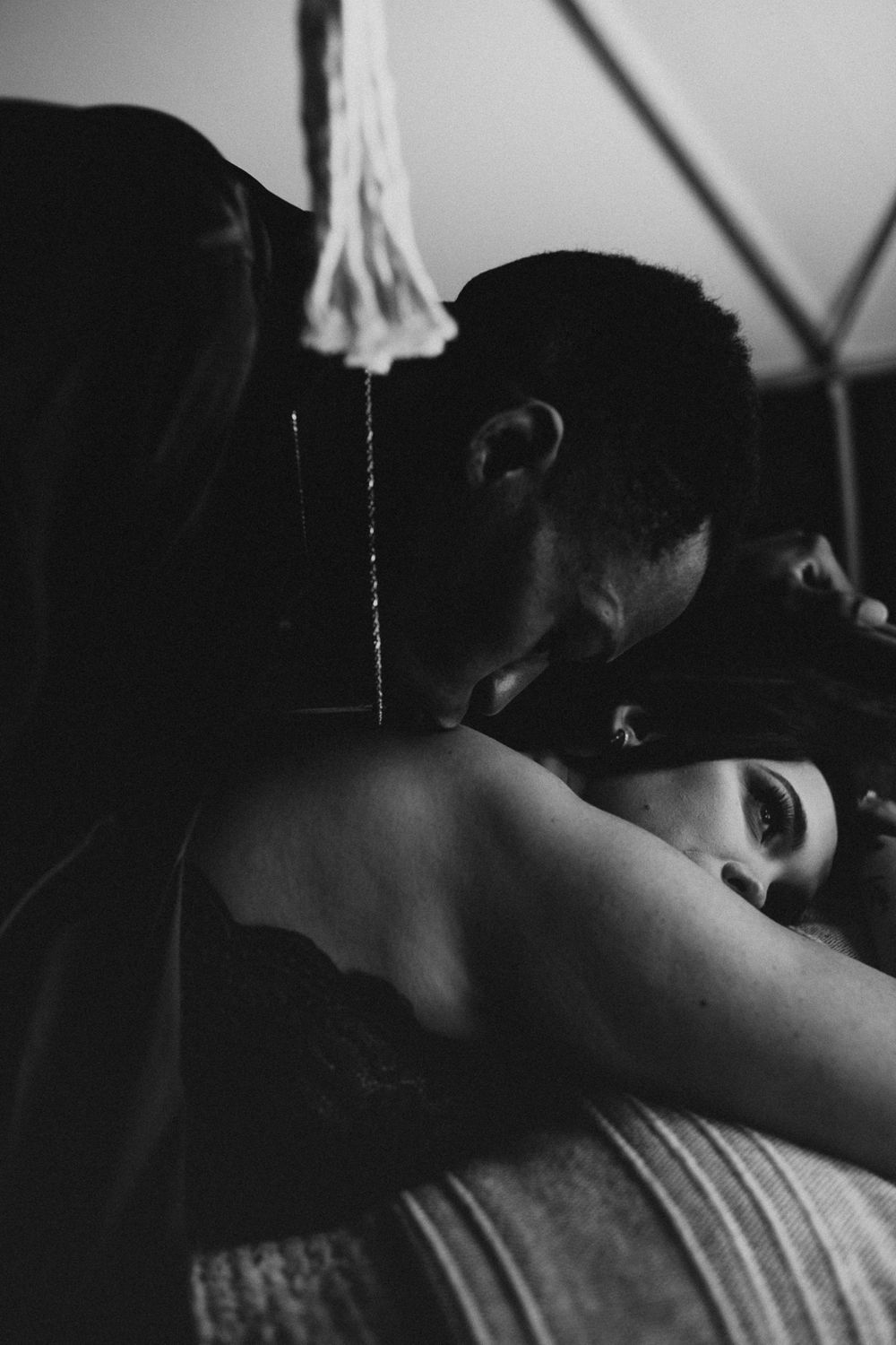 man kissing a woman's back during their intimate couples session