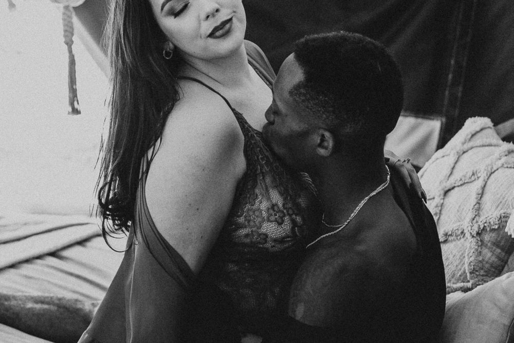 man kissing woman shoulder during their fall couples boudoir session