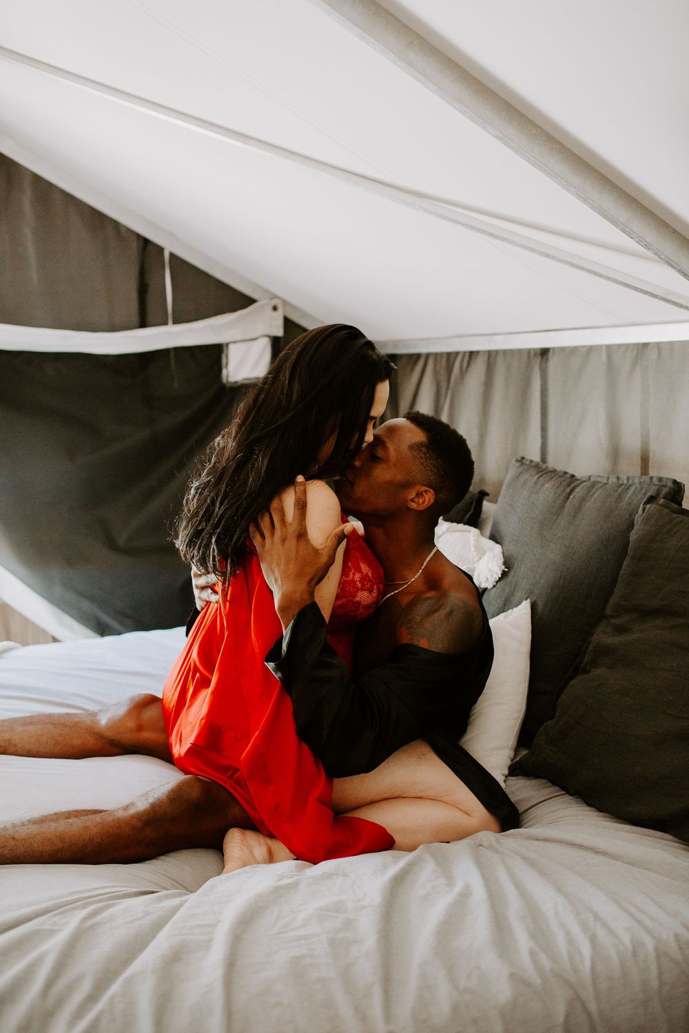 woman straddling man while they are kissing during their couples boudoir session